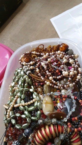 Large plastic storage box full of beads