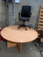Large round wooden meeting desk and black office swivel chair