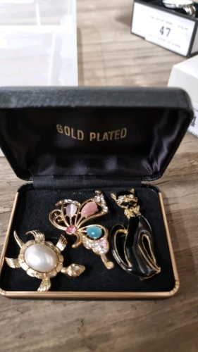 3 Gold plated brooches in a box