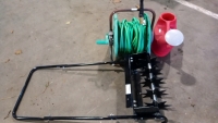 Black push spike lawn aerator, green/yellow Hozelock hosepipe with spray gun attached and red 10ltr Geeco watering can