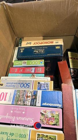 Box containing jigsaw puzzles and games including Monopoly, Trivial Pursuit, Jenga, Boggle, 4 in a Row and a puzzle board