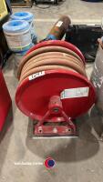 Fire hose on a reel for mounting on a wall.