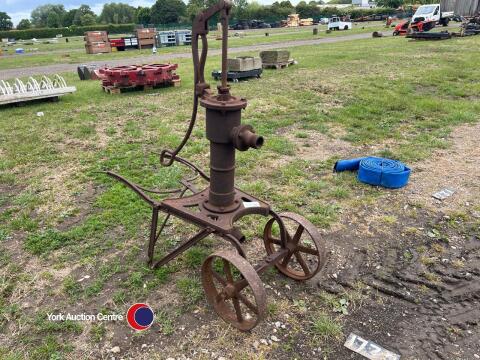 Vintage hand water pump on wheels