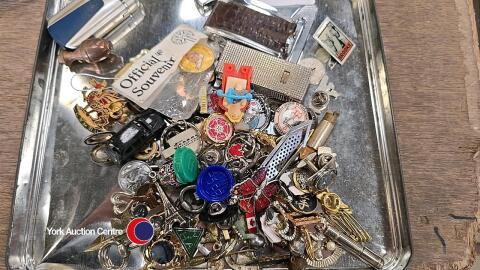 Tray of metal pin badges, keyrings and similar items
