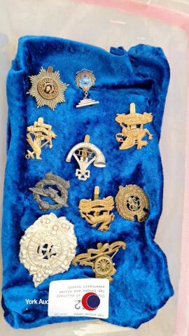 Collection of military cap badges and silver sweetheart brooch