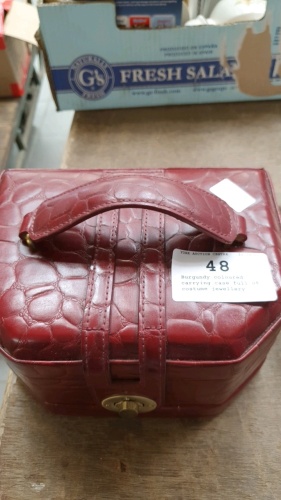 Burgundy coloured carrying case full of costume jewellery